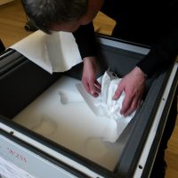 Der Kokosnusspokal wird vorsichtig verpackt