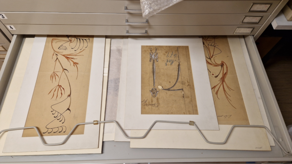 Foto: Mehrere Skizzen in der aufgezogenen Schublade eines Archivschranks