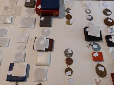In kleinen Tütchen verpackte Medaillen ausgebreitet auf einem Tisch.