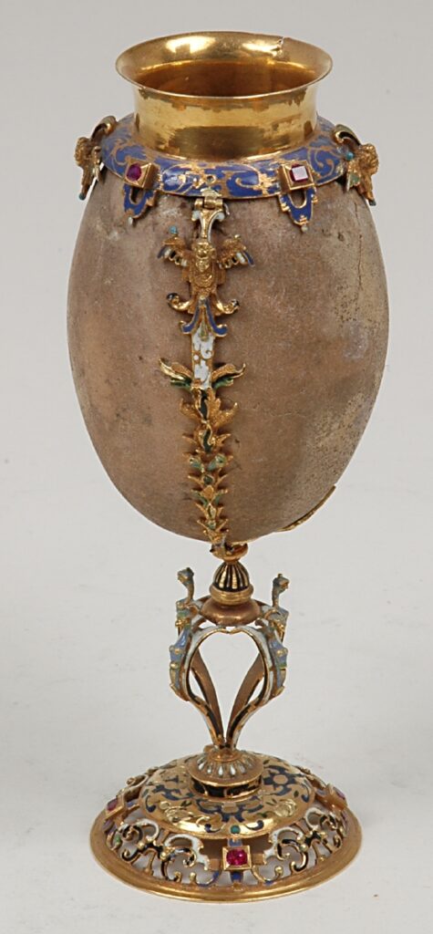 Ein bräunliches und rundes Gefäß mit feingearbeitetem Stil und Mundstück aus Gold.