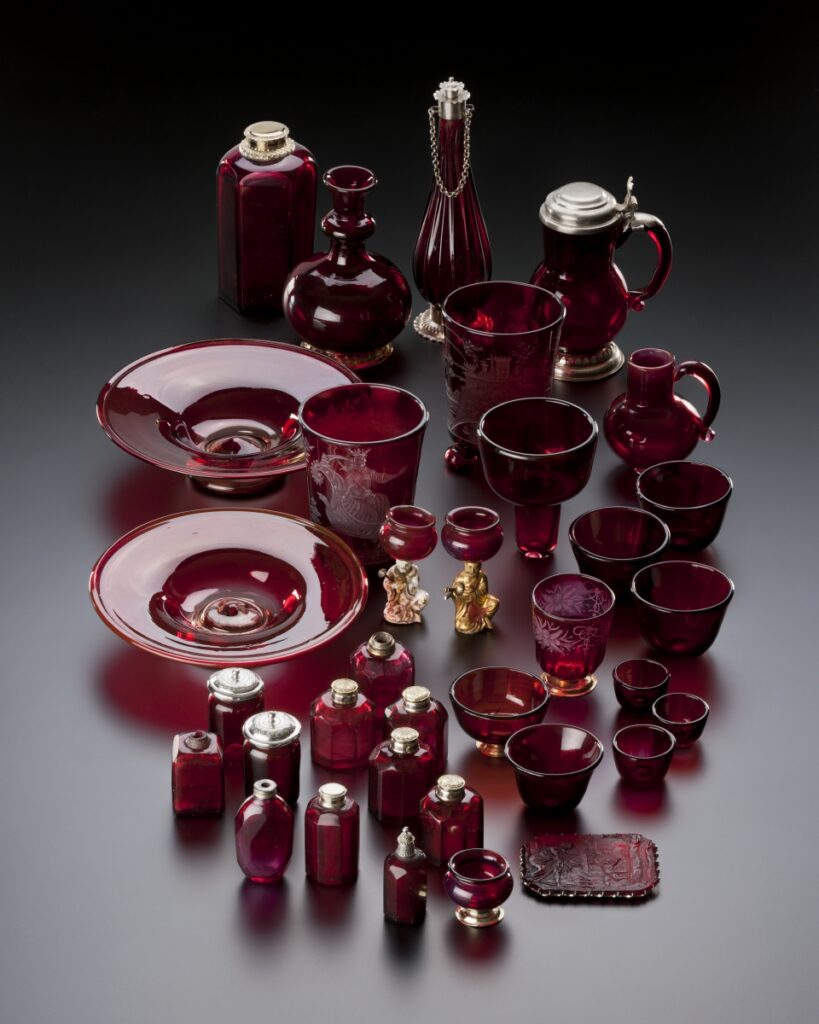 Eine Ansammlung von roten, gläsernen Tellern, Bechern, Kelchen, Karaffen, Schälchen und Fläschchen.