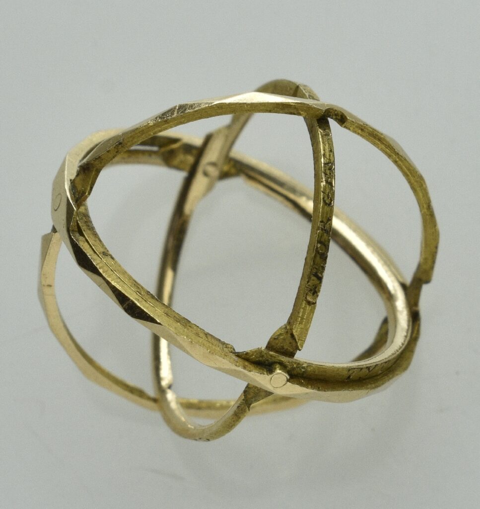 Vier dünne goldfarbene Ringe bilden eine kugelförmige Sphäre.