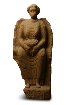 Steinstatue einer sitzenden Frau. Im Schoß hält sie eine Schale.