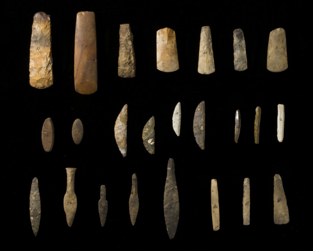 24 Steinobjekte in verschiedenen Formen und Größen vor dunklem Hintergrund.