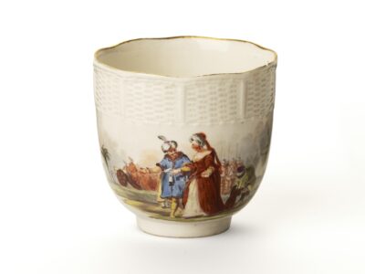 Eine helle Tasse mit regelmäßig leicht verbogenem Rand und Malerei.