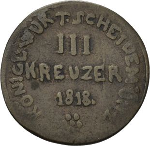 Eine historische, dunkle Münze mit der Inschrift mittig: "Drei Kreuzer 1818". Am Rand entlang steht die Inschrift "Koenigl: Wurt: Scheidemünz"