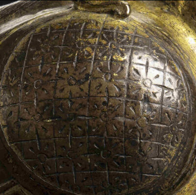 Detailaufnahme: Ornamentale, schraffurartige Gravuren mit Vergoldung und Silbertauschierungen am Korpus des Gefäßes.
